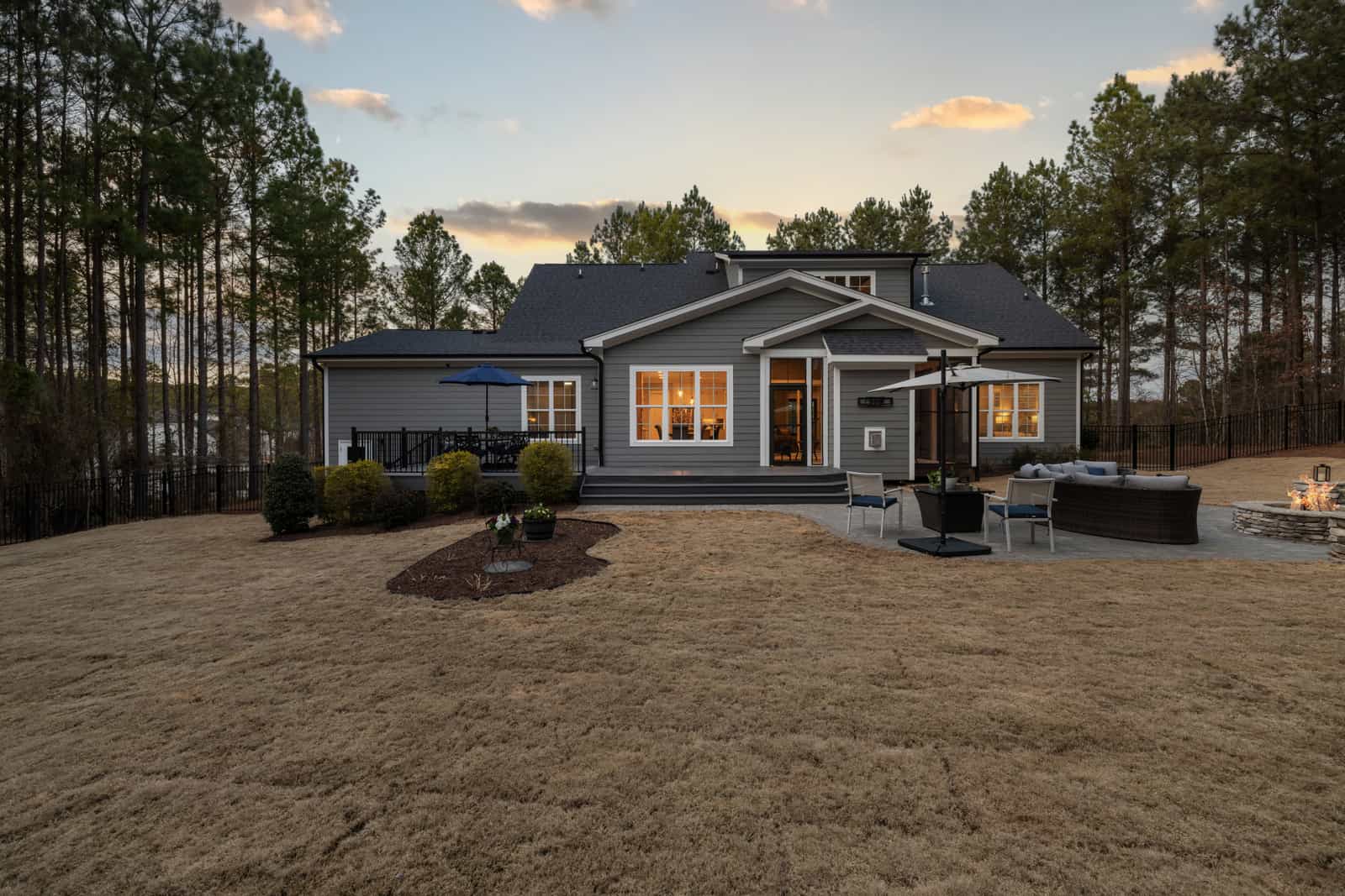 A modern house and backyard lawn lit at sunset